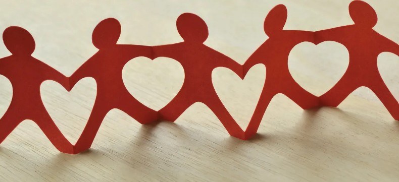 Red paper-chain figures holding hands, joined by hearts